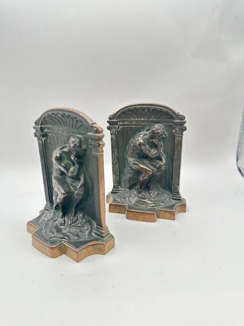 Pair of bronze Thinker bookends shown at an angle on white background