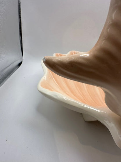 Side view of the peach shell serving dish showing the fish bowl's fluted tail