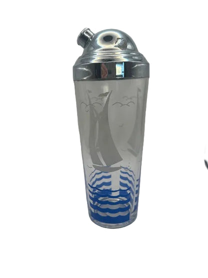 Sailboat cocktail shaker, front view of frosted glass with sailboat, gulls and blue waves