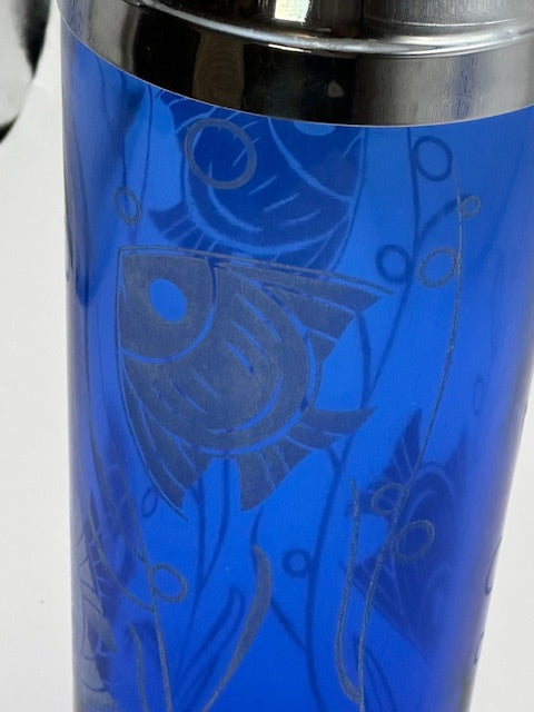 Close-up of etched fish and seaweed design on cobalt blue cocktail shaker