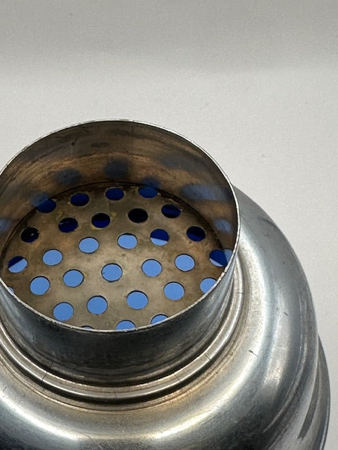 Top view of the cobalt shaker's perforated chrome strainer with blue glass below