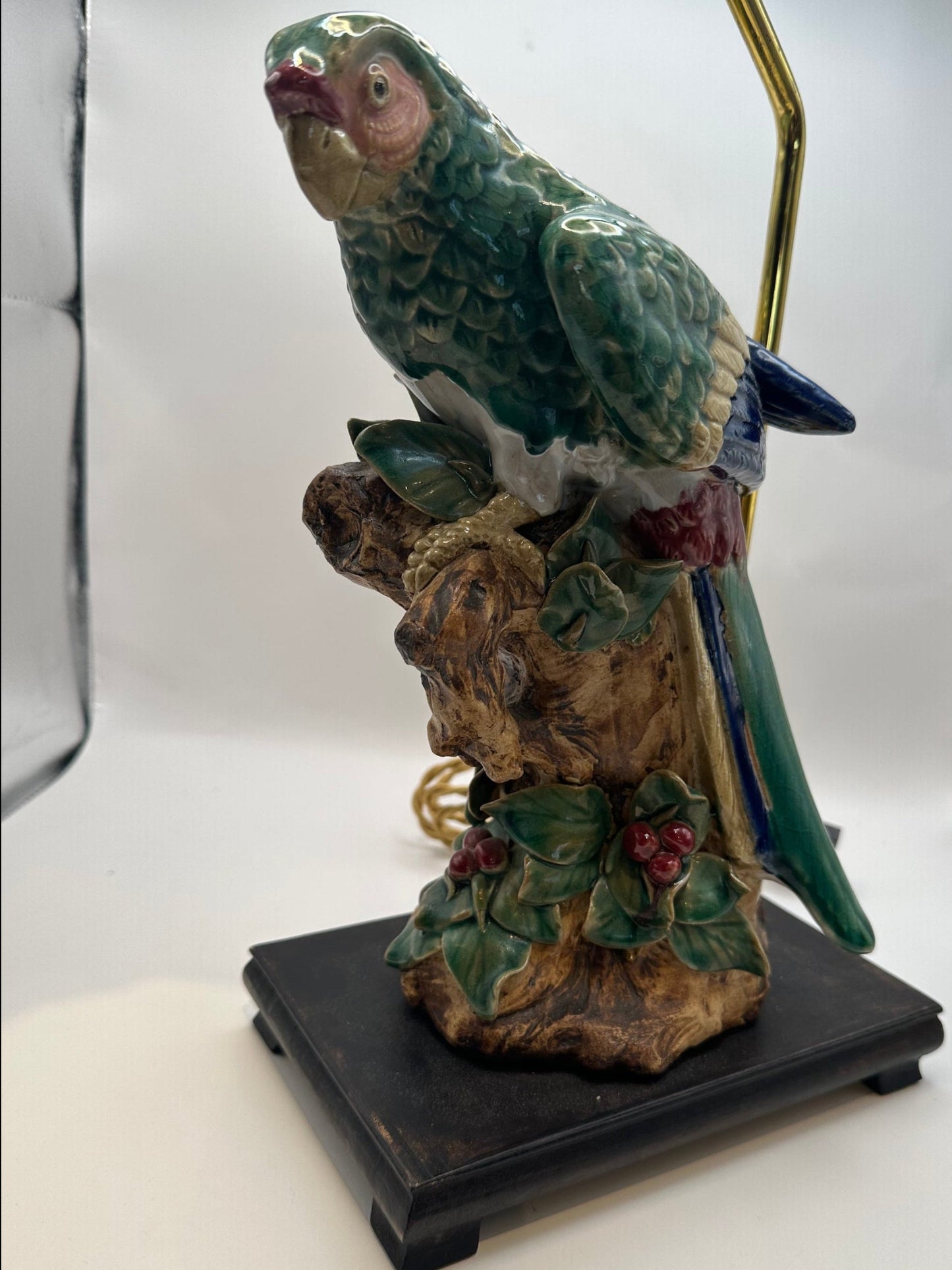 Majolica parrot lamp on a black wood base with hand-painted leaves and red berries at the branch