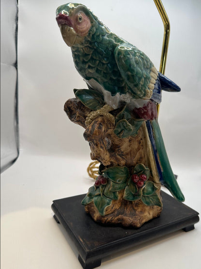 Majolica parrot lamp on a black wood base with hand-painted leaves and red berries at the branch