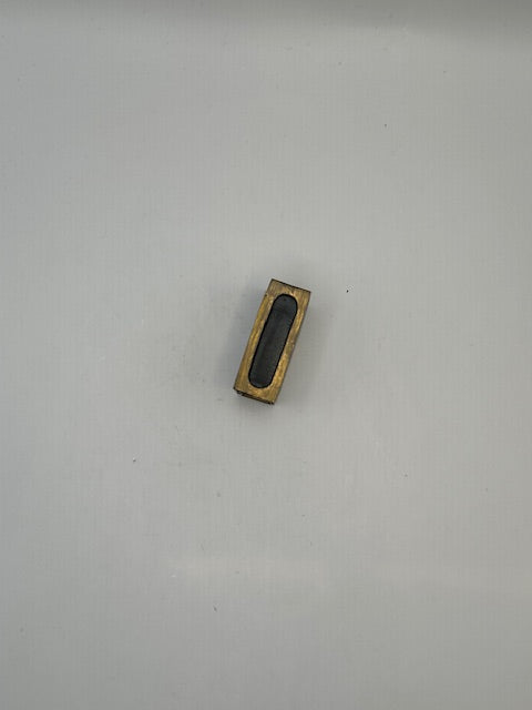 Brass open frame of the matchbox cover showing the hollow slot that holds a matchbox