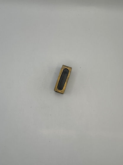 Brass open frame of the matchbox cover showing the hollow slot that holds a matchbox