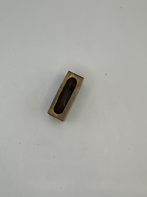 Brass matchbox-cover frame viewed from above showing the open hollow interior