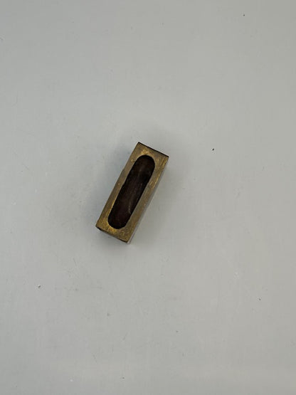 Brass matchbox-cover frame viewed from above showing the open hollow interior