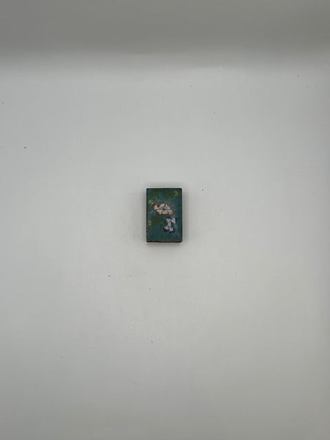 Aqua floral cloisonne matchbox cover shown small against a gray background