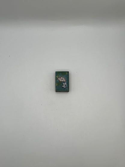 Aqua floral cloisonne matchbox cover shown small against a gray background