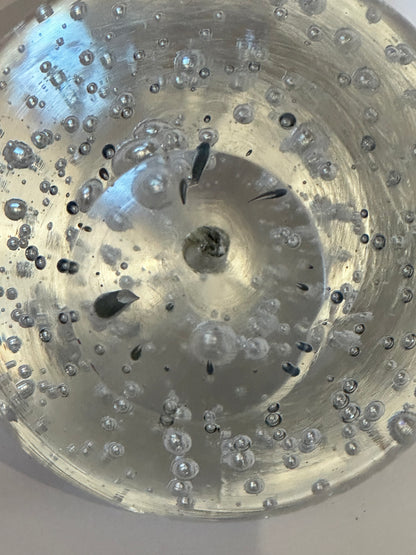 Extreme close-up inside vintage bubble glass sphere showing bubbles and dark inclusions