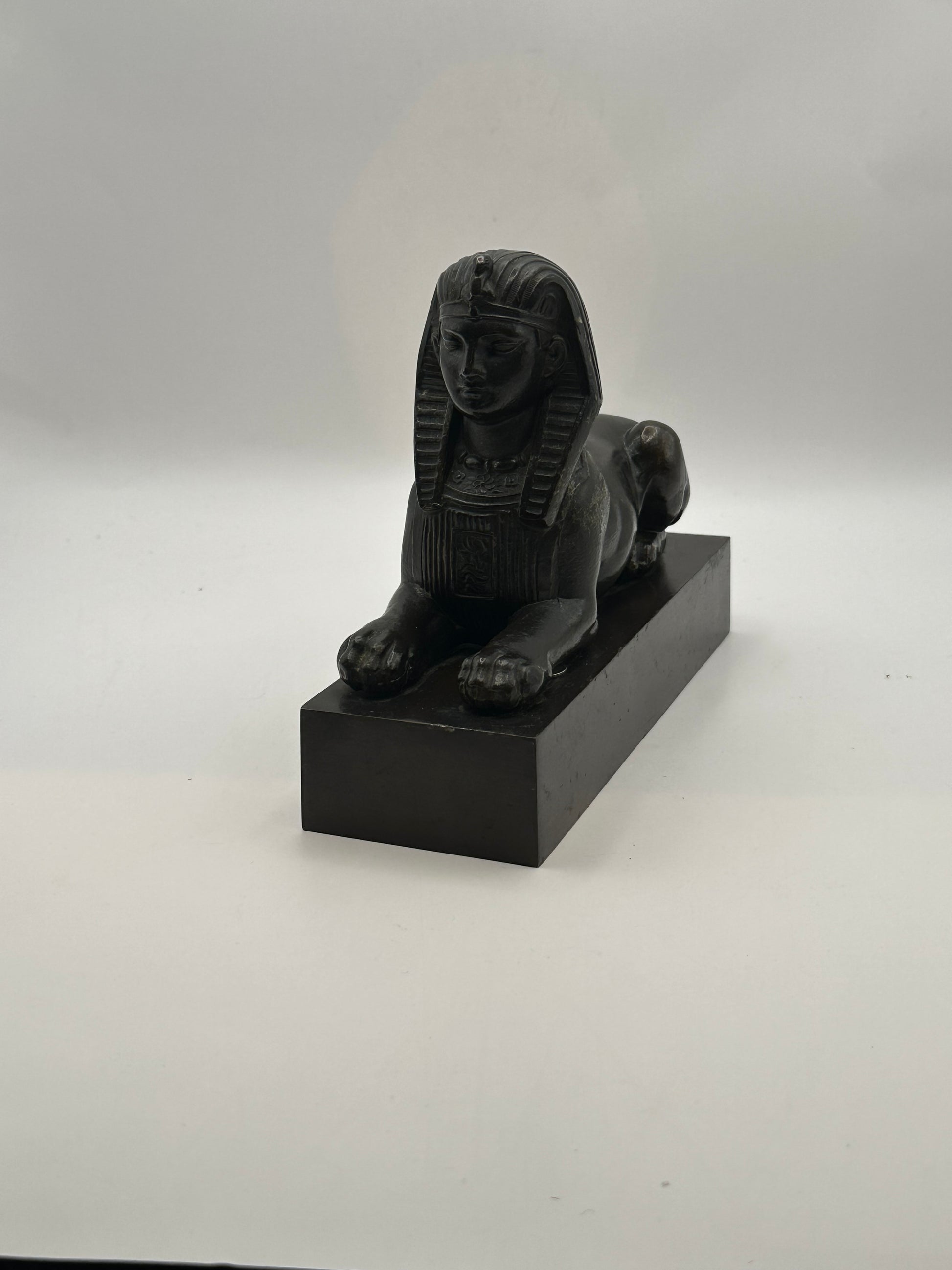 Vintage Egyptian Revival bronze sphinx statue, three-quarter front view on black base