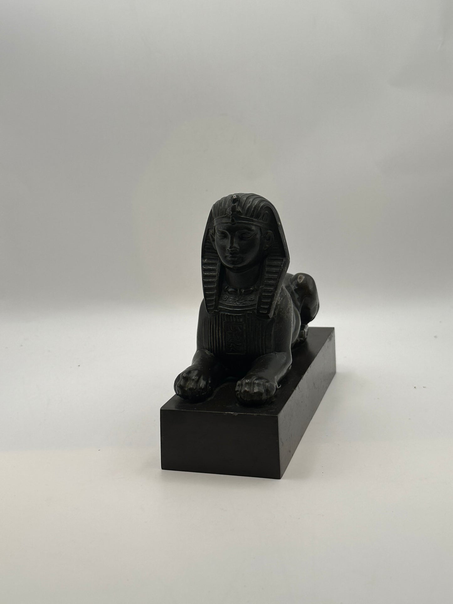 Vintage Egyptian Revival bronze sphinx statue, front view showing pharaoh face and forepaws