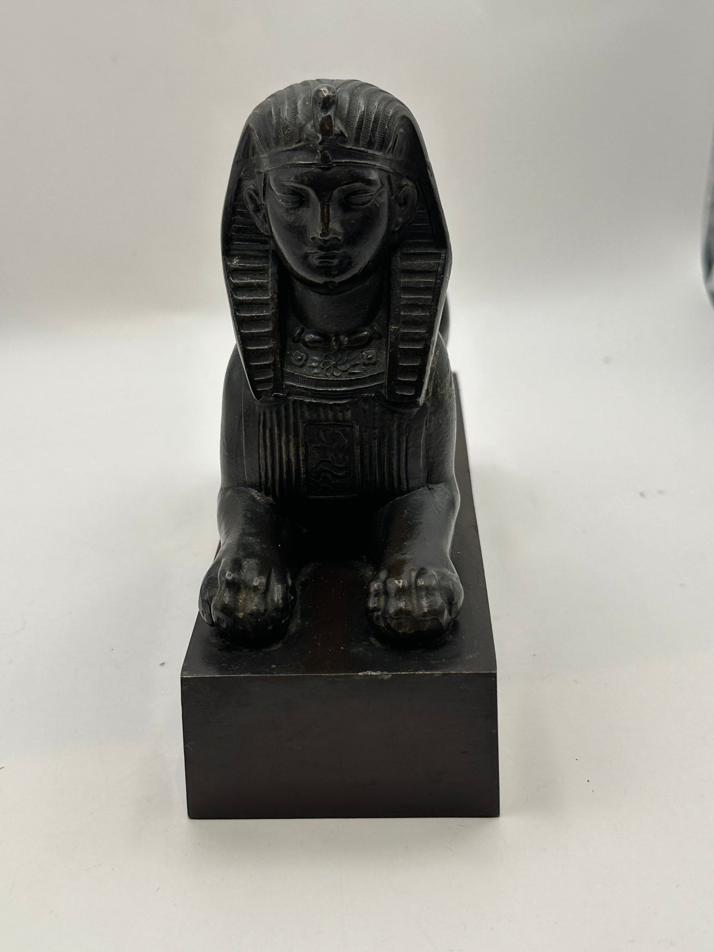 Vintage Egyptian Revival bronze sphinx, head-on close view of face, headdress and forepaws
