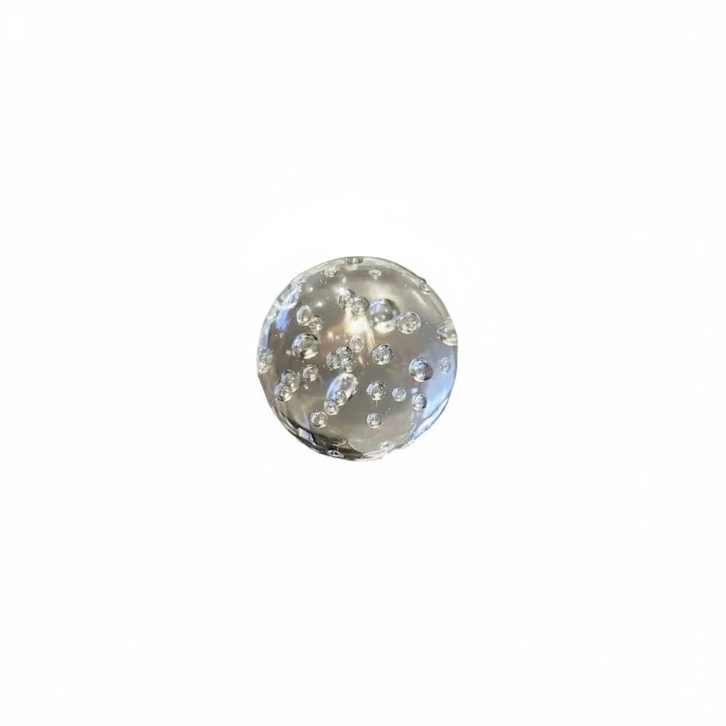 Clear controlled-bubble glass sphere paperweight on a white background