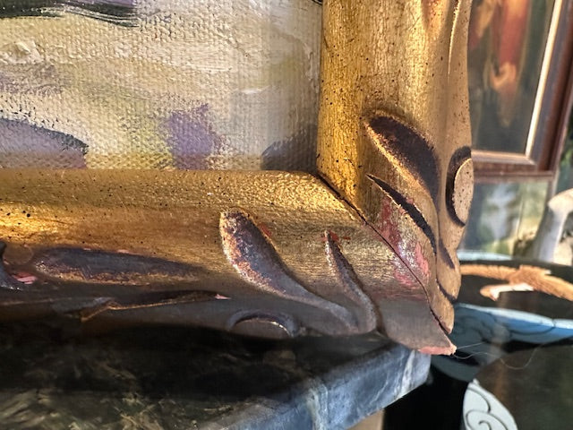 Close-up of carved gilt frame corner on vintage still life painting, leaf-scroll detail