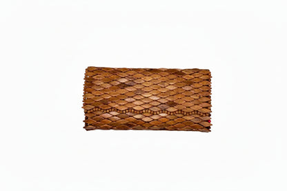 Top-down view of Ma'aM Kind woven wood clutch with tan scale-tiled surface