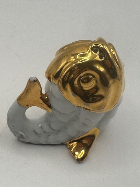 Close-up of one vintage porcelain fish shaker with glossy gold head and white scaled body