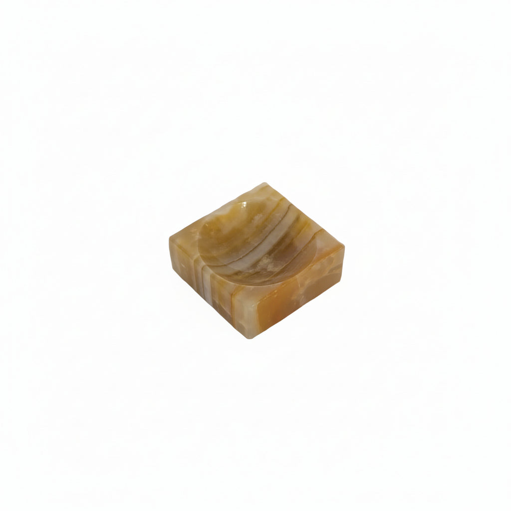 Vintage banded onyx salt cellar, angled view of the carved amber and cream stone with shallow well