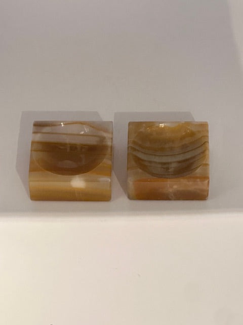 Vintage onyx salt cellars, pair angled view showing banded amber stone and carved wells