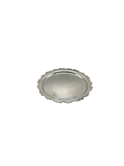 Vintage silver-plate round serving tray with scalloped border, angled view