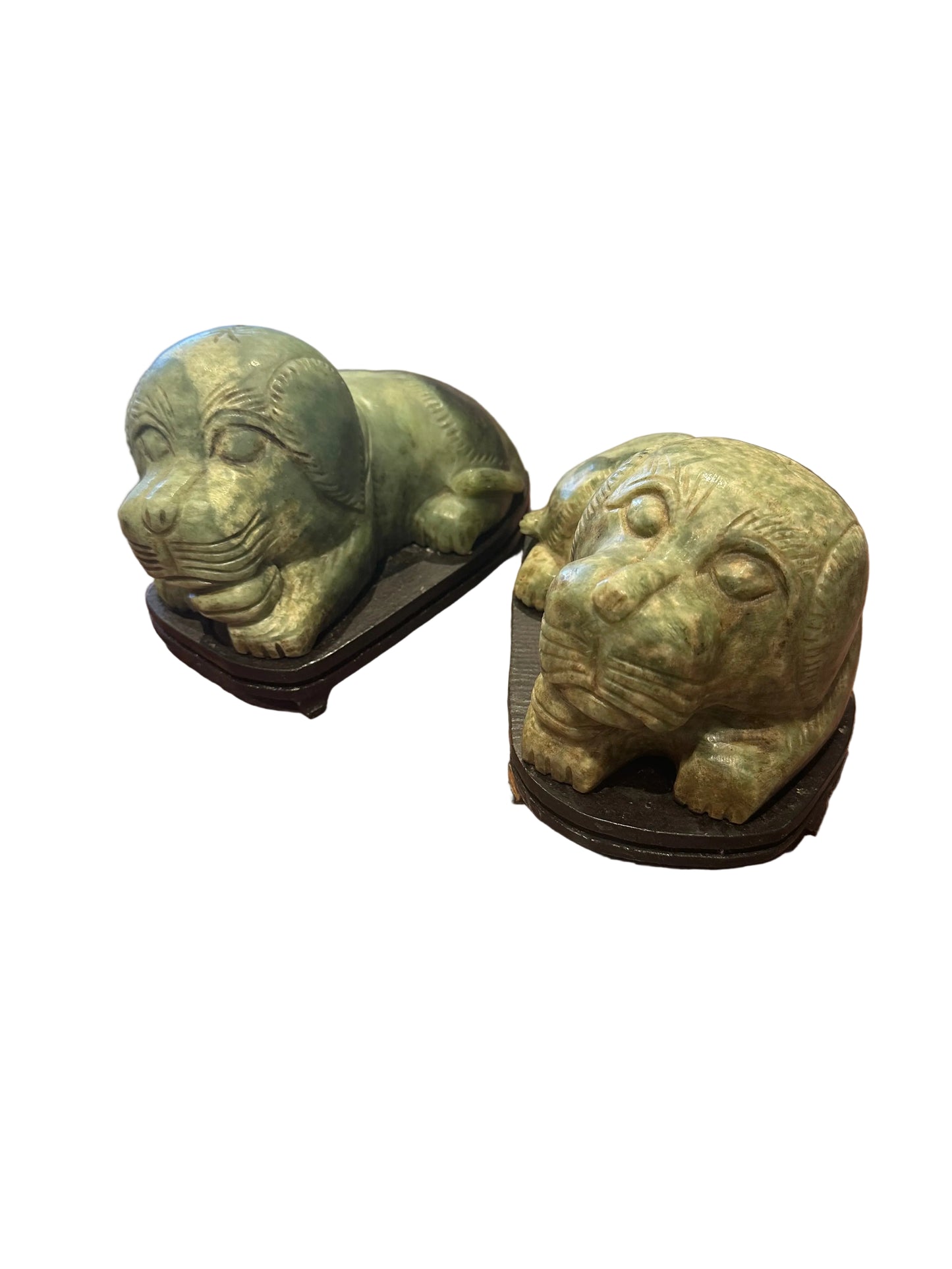 Angled view of the pair of carved stone foo dogs resting on wooden bases