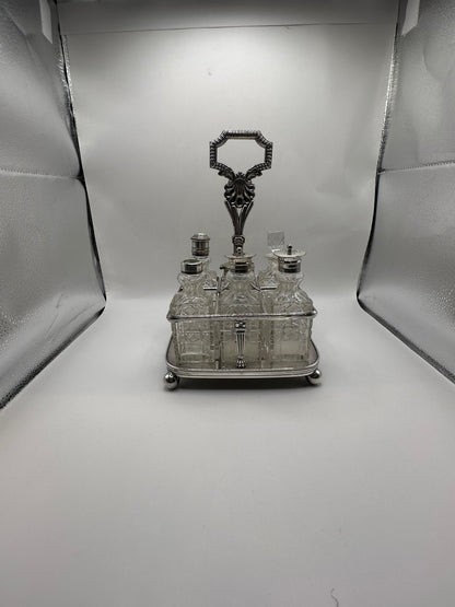 Antique cruet set fully assembled, all cut-glass bottles seated in the silver caddy, front view
