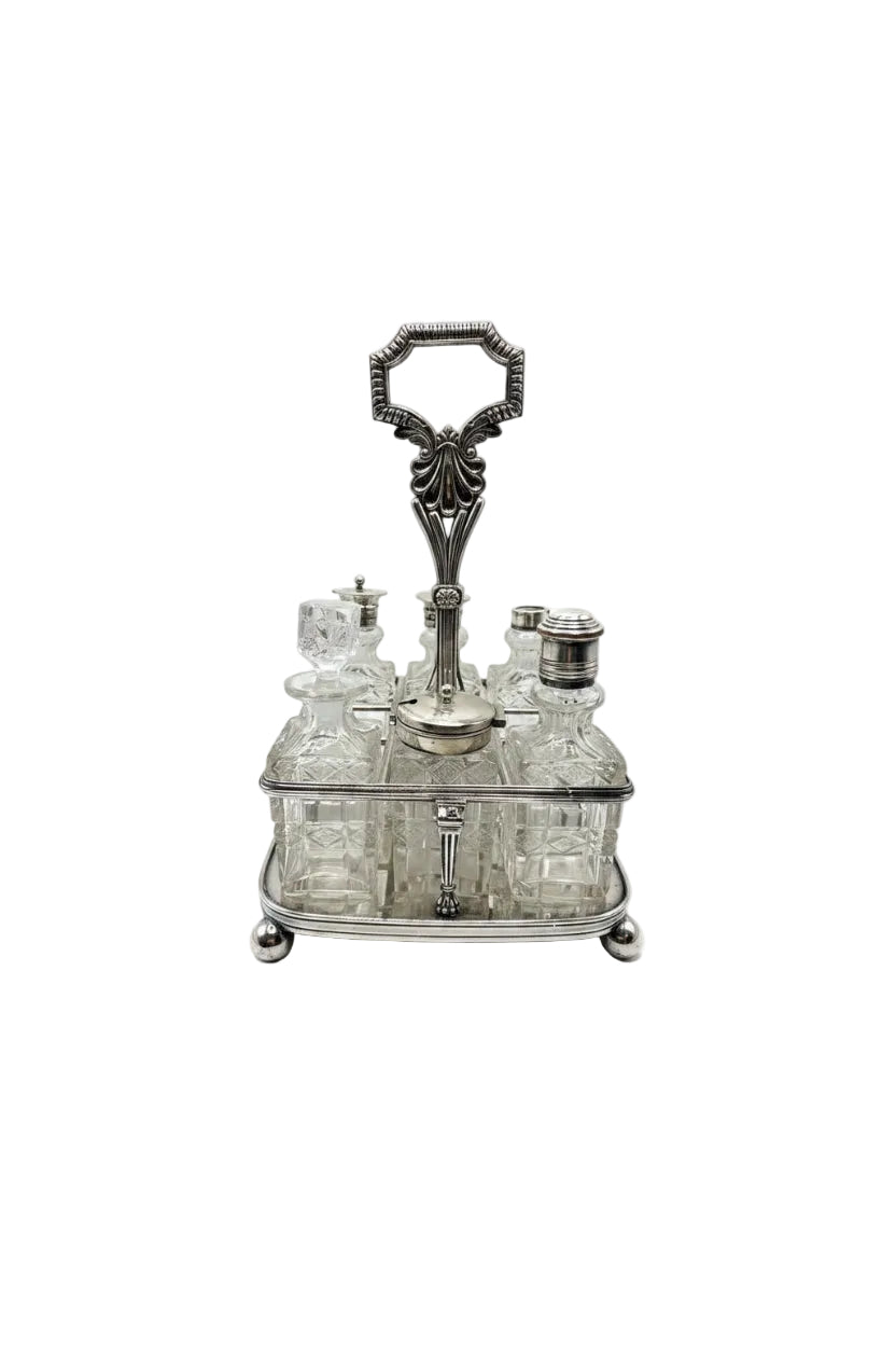 Antique 7-piece cruet set, cut-glass bottles in a silver stand with ornate loop handle, front view