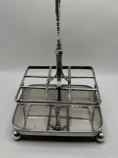 Close-up of the antique cruet set's silver caddy frame, base and ball feet
