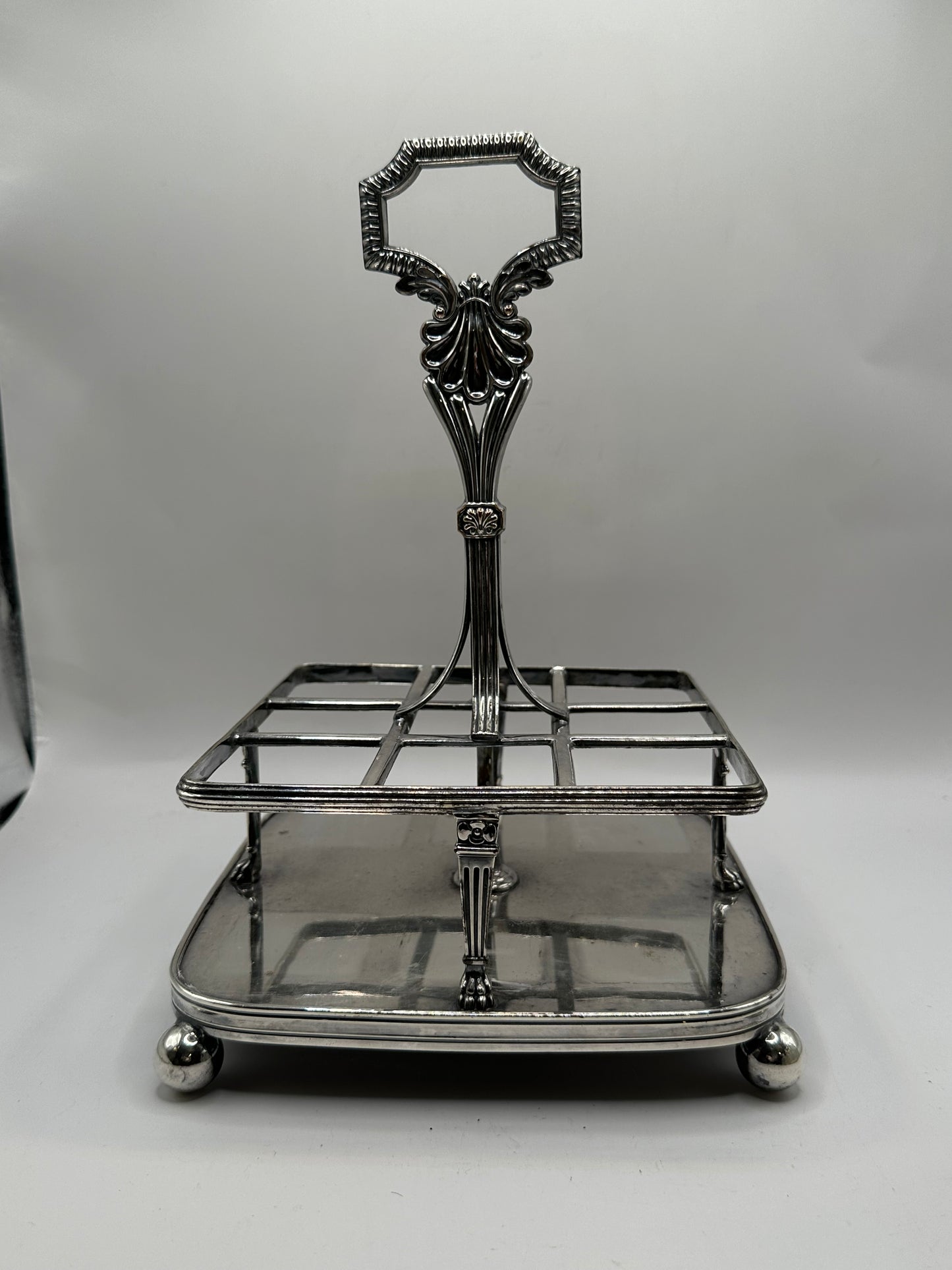 Antique cruet set, empty silver caddy frame on ball feet with ornate scroll handle
