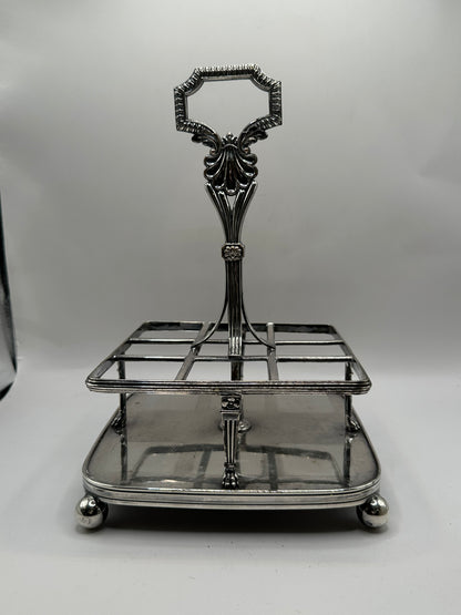 Antique cruet set, empty silver caddy frame on ball feet with ornate scroll handle