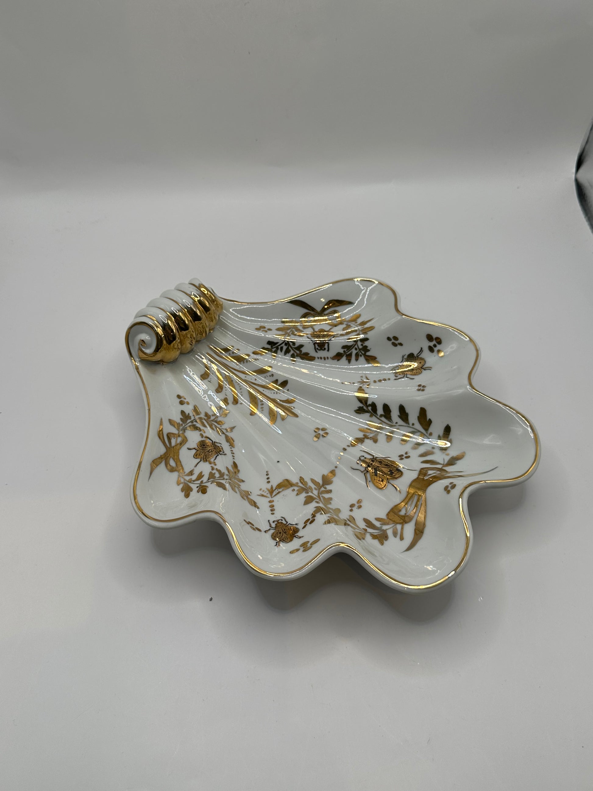 Vintage Limoges shell dish, three-quarter view of gilt scroll handle and decorated well