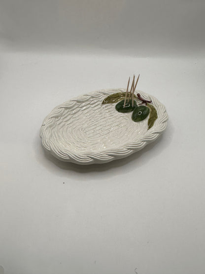 Italian ceramic olive dish, angled view with toothpicks tucked beside the olive cluster