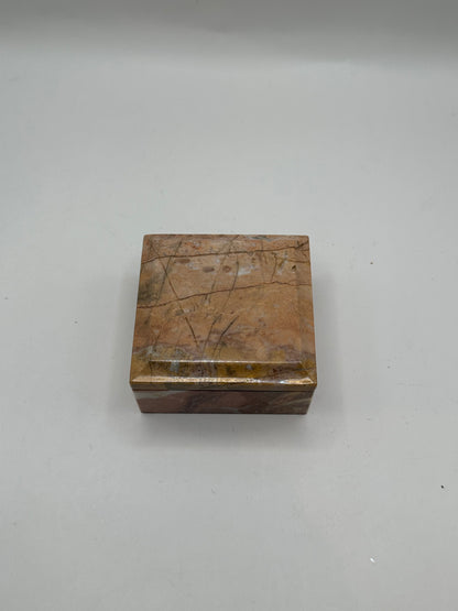 Closed rose marble lidded box, top-down view of polished grain
