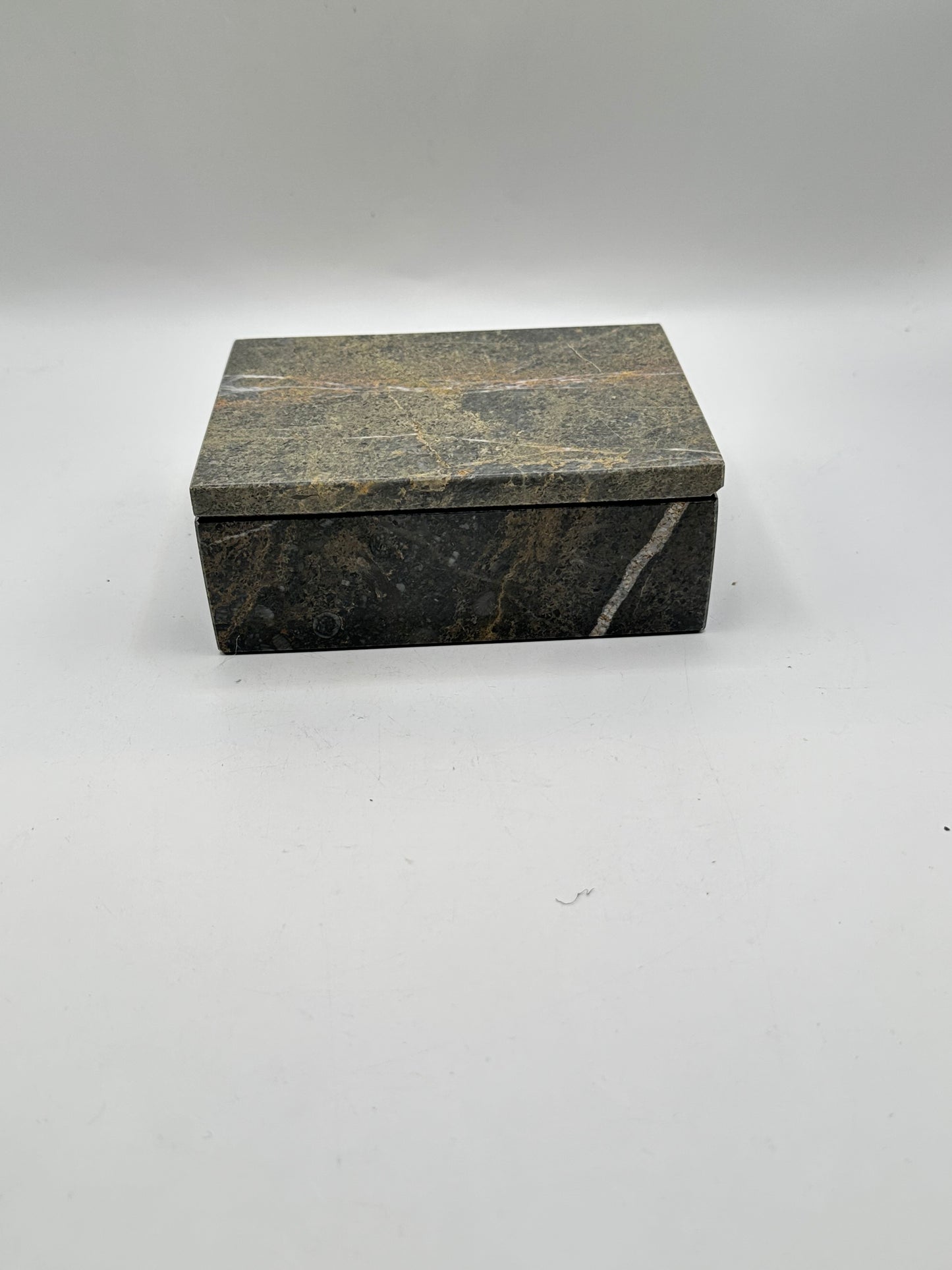 Closed gray stone lidded box, three-quarter view with white veining