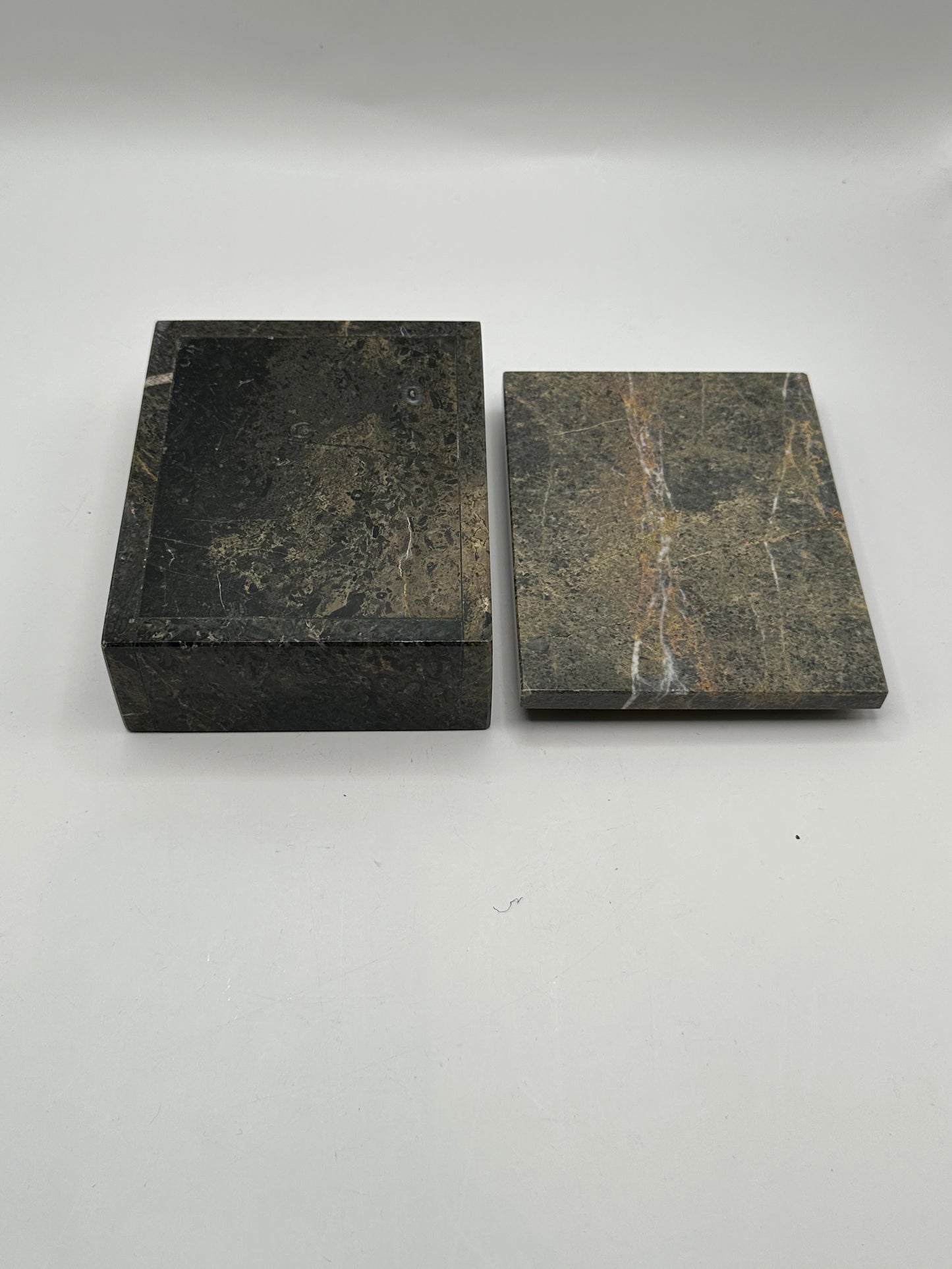 Gray stone box with lid removed beside it, showing veined underside