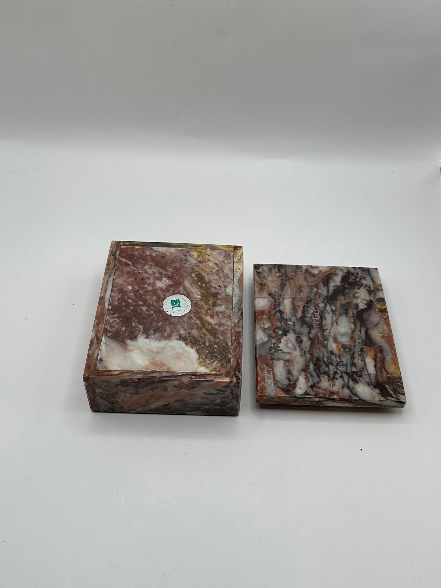 Rust marble box with lid removed beside it, showing underside with maker's label