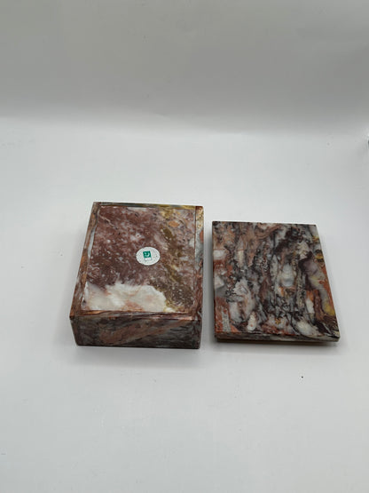 Rust marble box with lid removed beside it, showing underside with maker's label