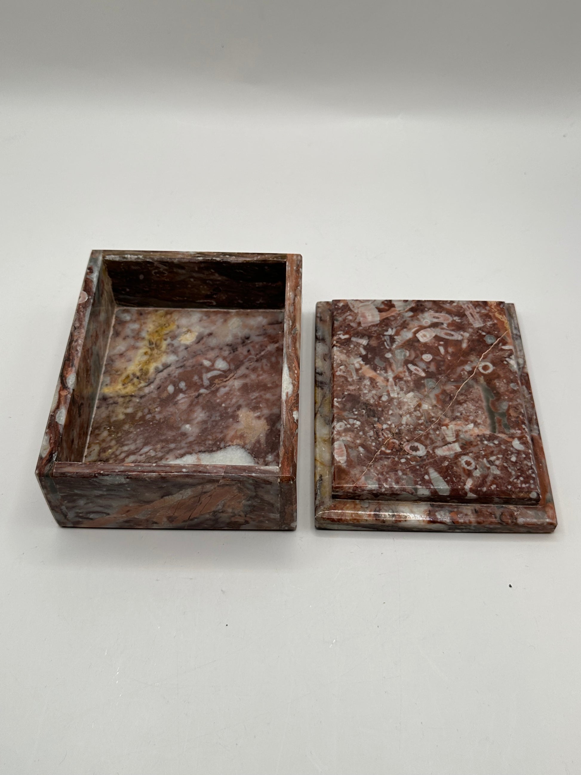 Open rust marble box with lid aside, revealing polished interior