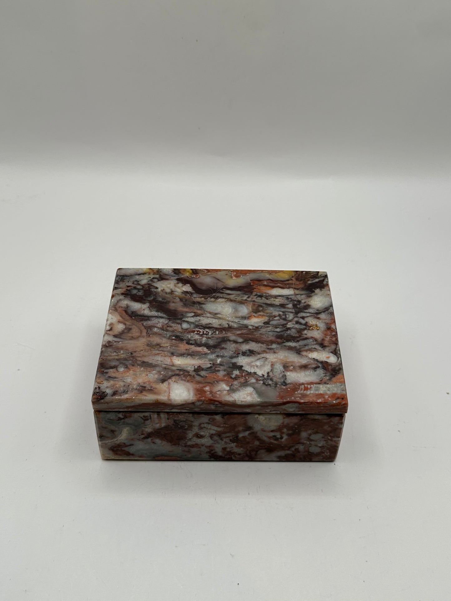 Closed rust multi marble lidded box, front view of mottled veining