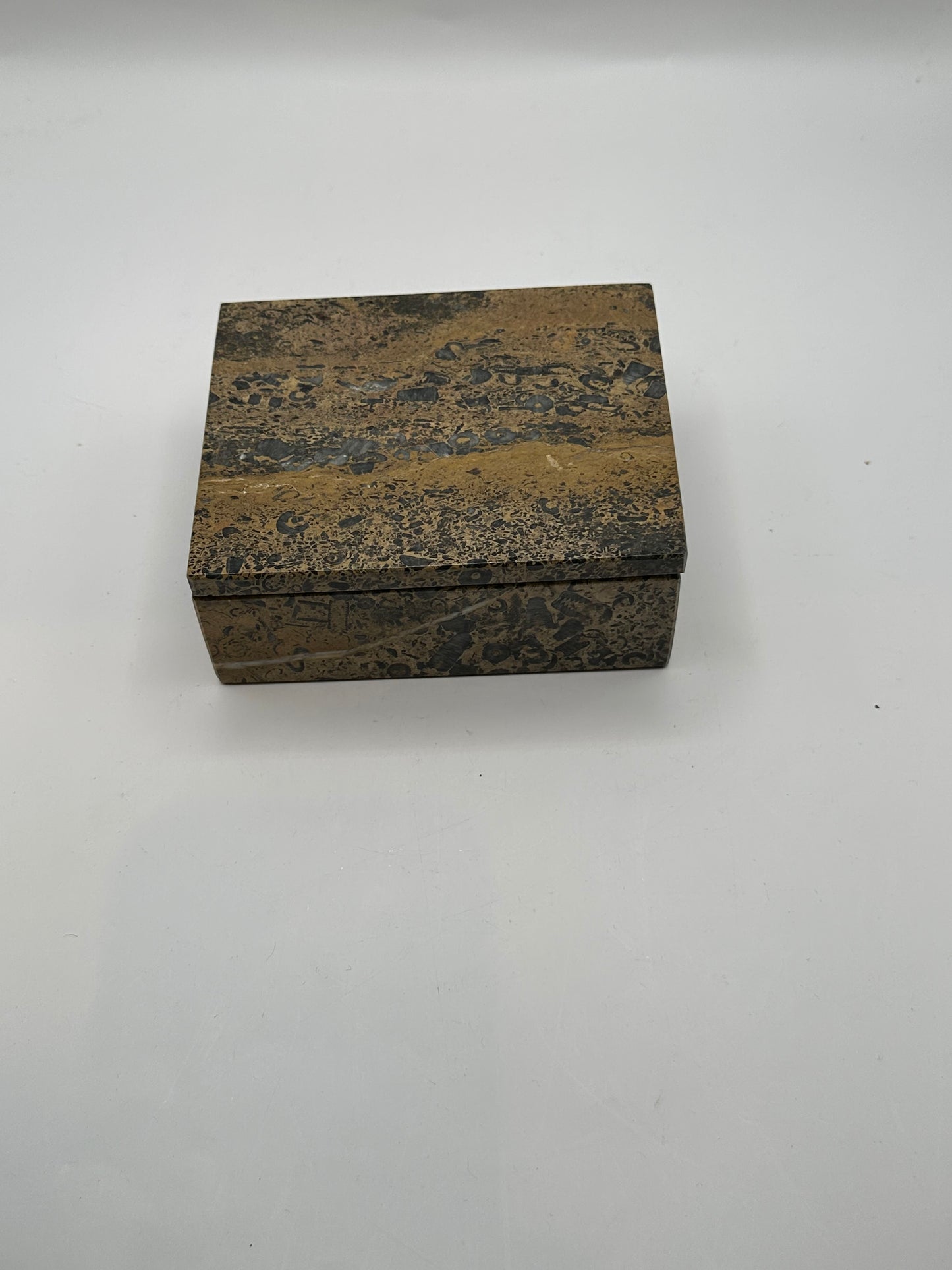 Closed brown multi stone box, three-quarter view of polished speckled surface