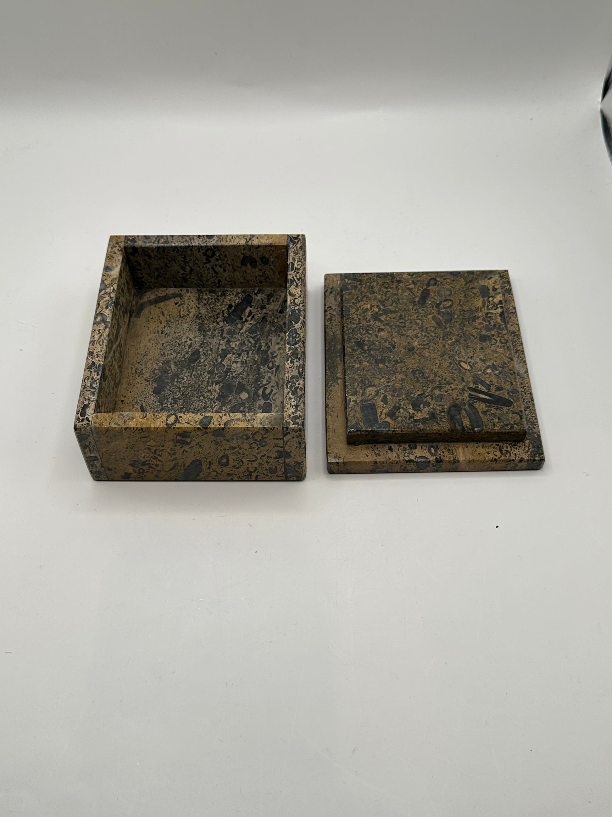 Open brown stone box with lid set aside, revealing the hollow interior