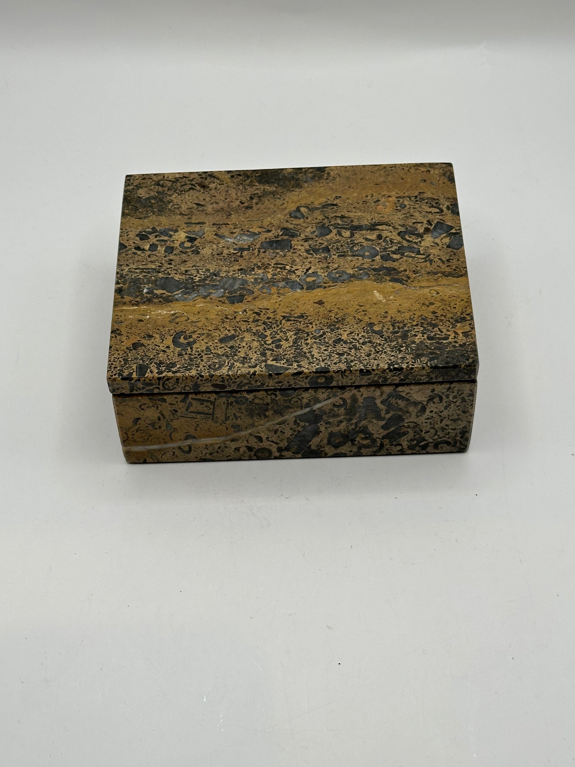 Brown multi stone lidded box, closed, three-quarter view showing speckled grain