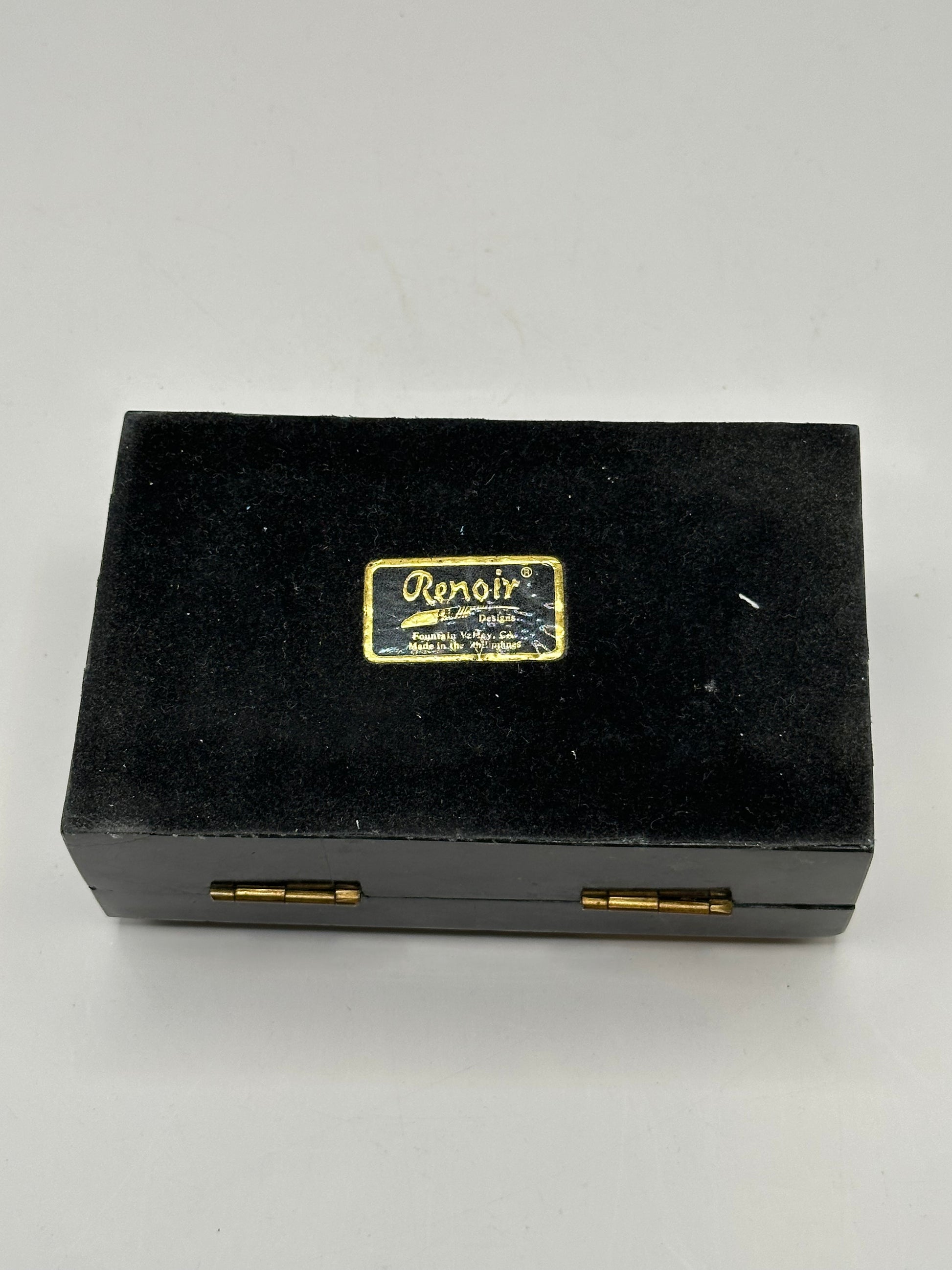 Closed black tessellated stone box, top-down view of tiled pattern