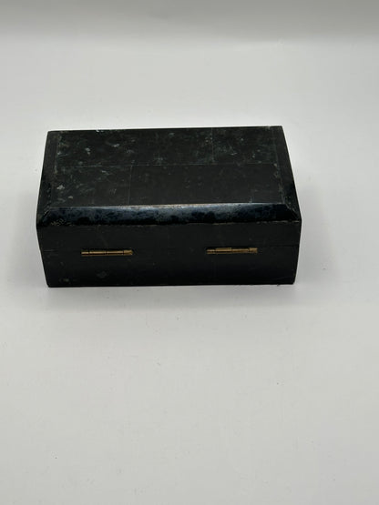 Closed black tessellated hinged box with brass hinges, front view