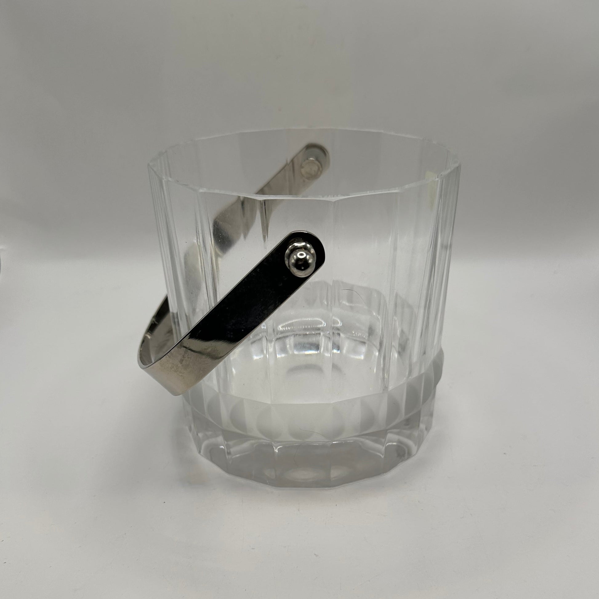 Close-up of the crystal ice bucket's silver swing handle against the faceted body
