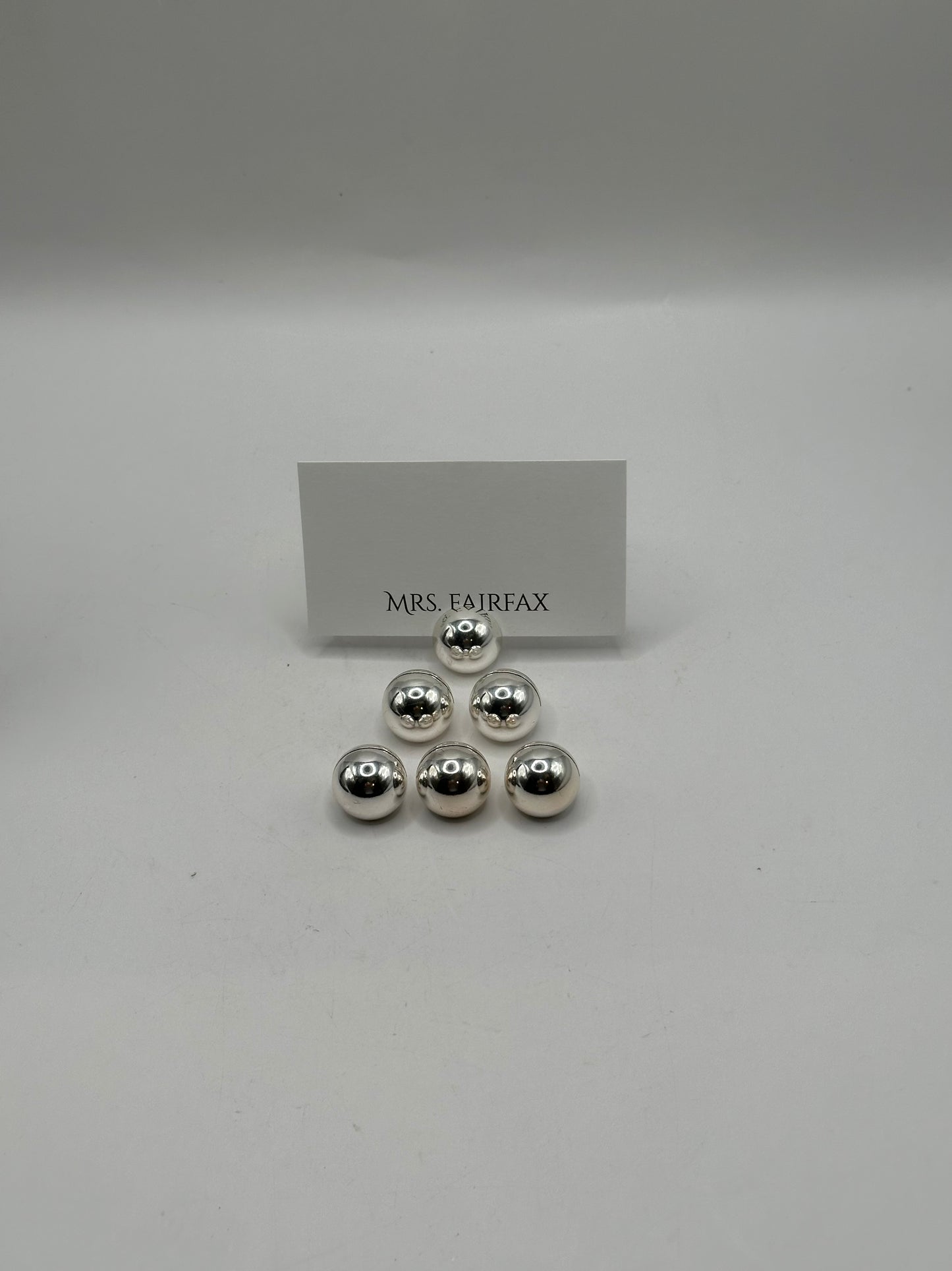MCM stainless steel spherical place card holders, six polished spheres clustered with a place card
