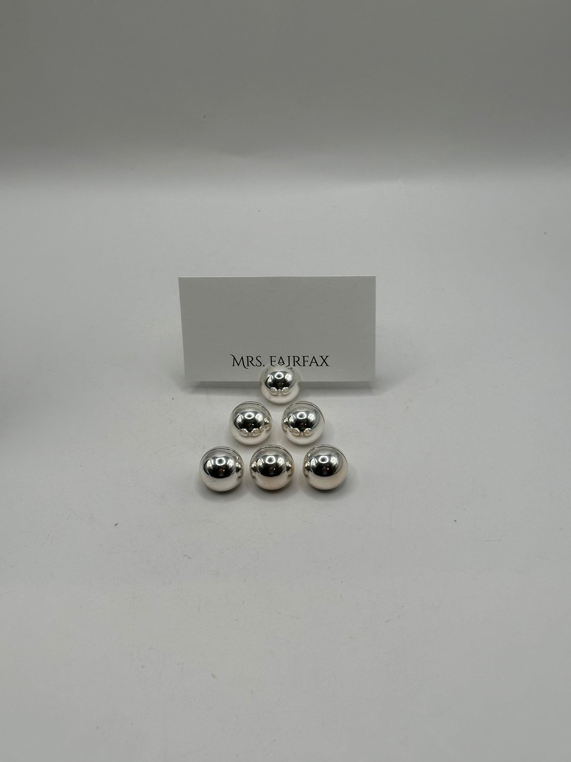 MCM stainless steel spherical place card holders, six polished spheres clustered with a place card