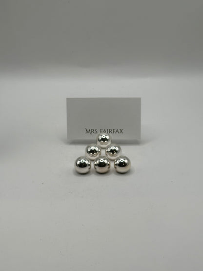 MCM stainless steel spherical place card holders, six spheres stacked with a place card behind