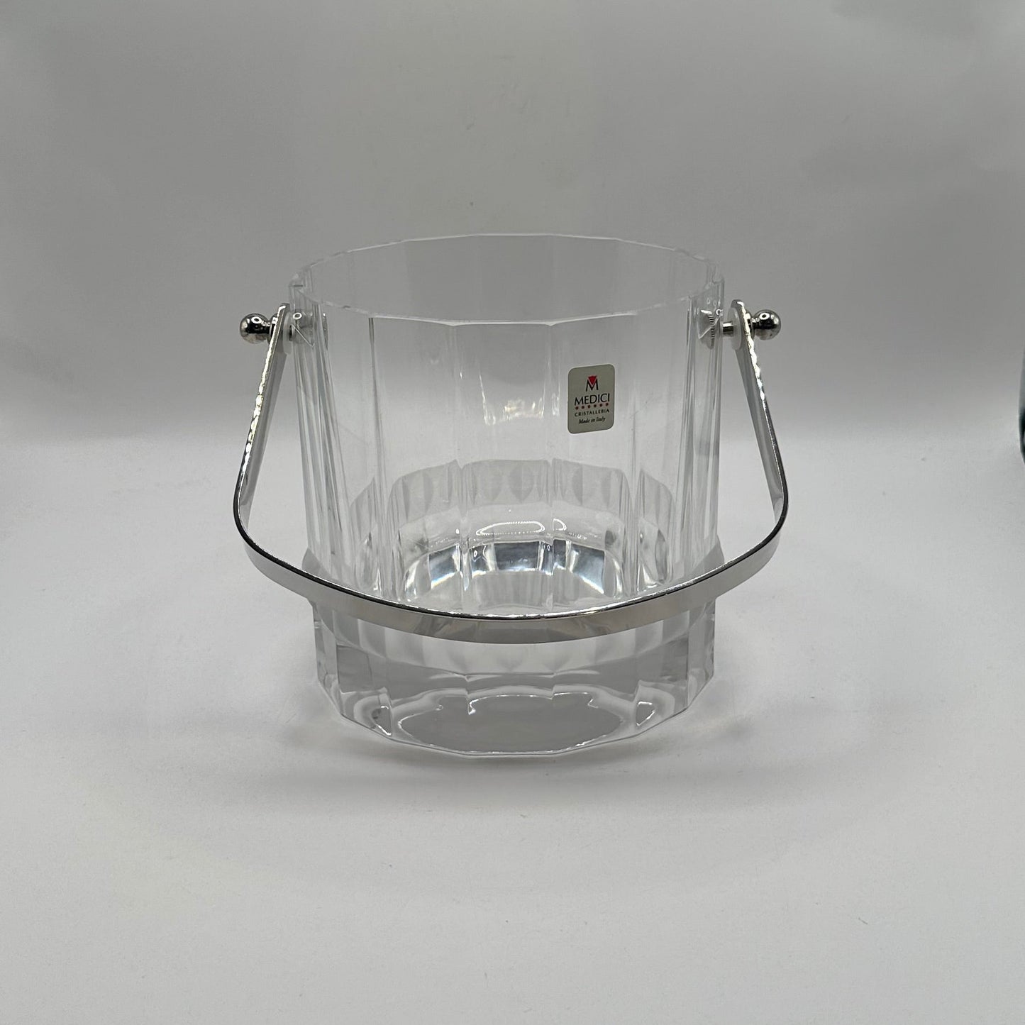 MCM crystal ice bucket, front view with handle lowered and gold Medici Crystal label