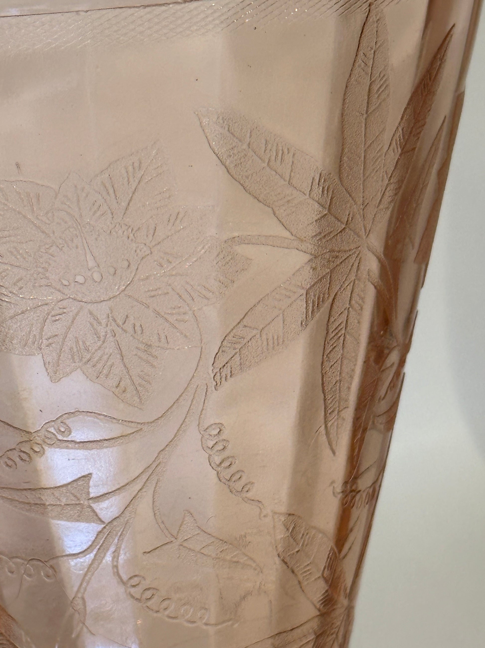 Close-up of etched floral and leaf pattern on pink Depression glass pitcher